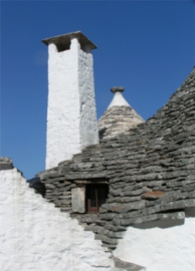 Ein Dach eines Trullo, mit kleinem Fenster, langem Schornstein.